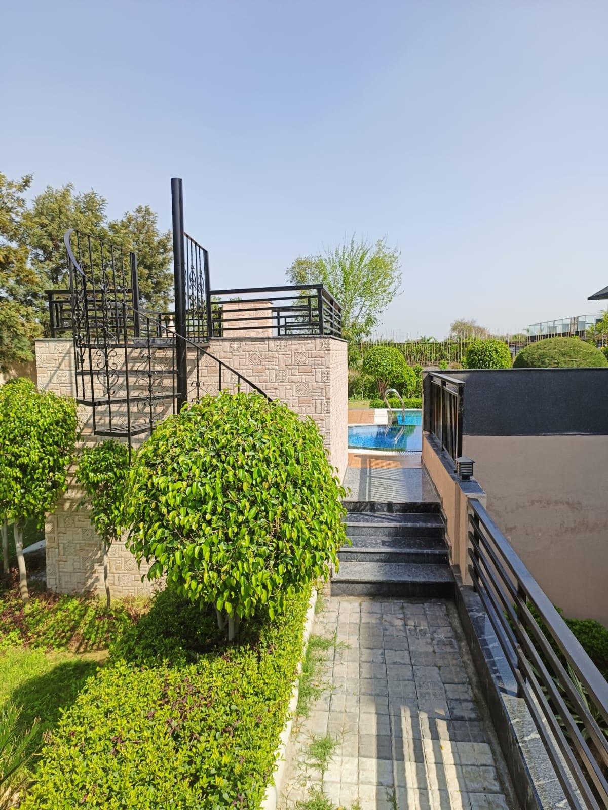 Elegant farmhouse exterior with garden and open space in Gurgaon